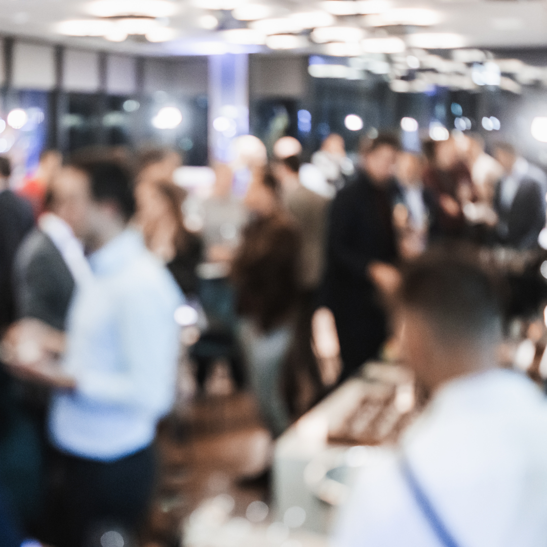 A blurred photo of people attending a marketing event.