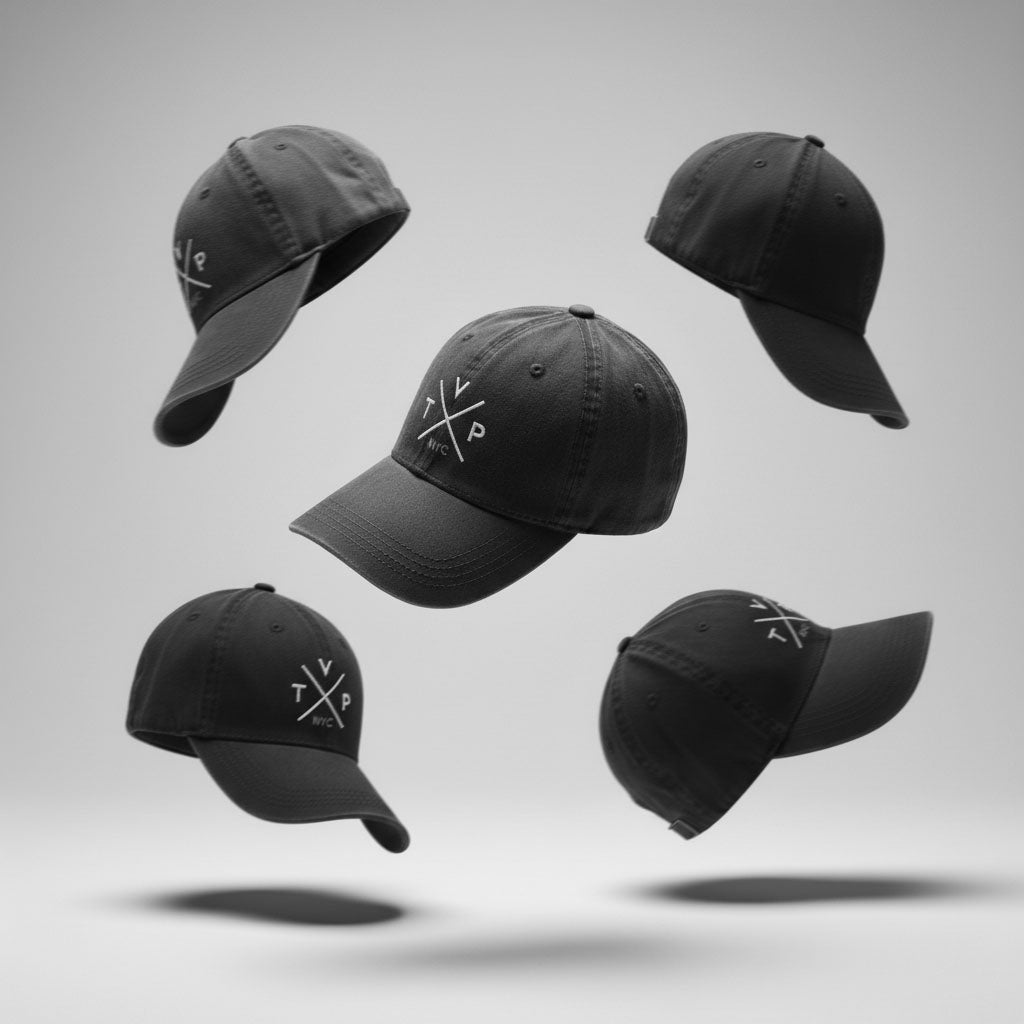 Custom Embroidered Hats, TVP NYC Dad Hat, Premium Brand Headwear, Custom Swag Solutions, Professional Hat Embroidery. A professional studio composition showing five black "TVP NYC" embroidered dad hats floating in mid-air from various angles, casting soft shadows on a grey background.