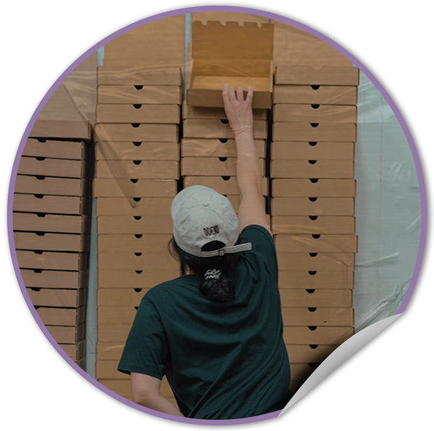 Person stacking sustainable cardboard boxes inthe TVP NYC warehouse