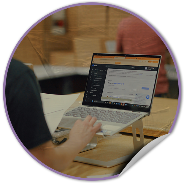 Person using a laptop on a wooden desk in an office setting at TVP NYC